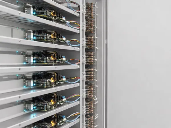 A rack of devices under test, board after board wired into the bench and powered up.